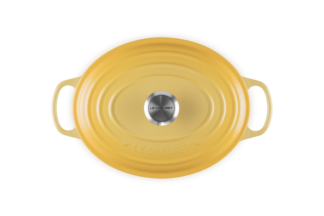 Yellow oval cast iron casserole with handles on a white background