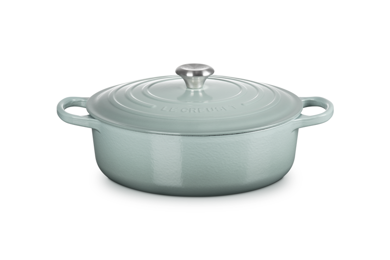 Light blue cast iron risotto pot with lid on a white background