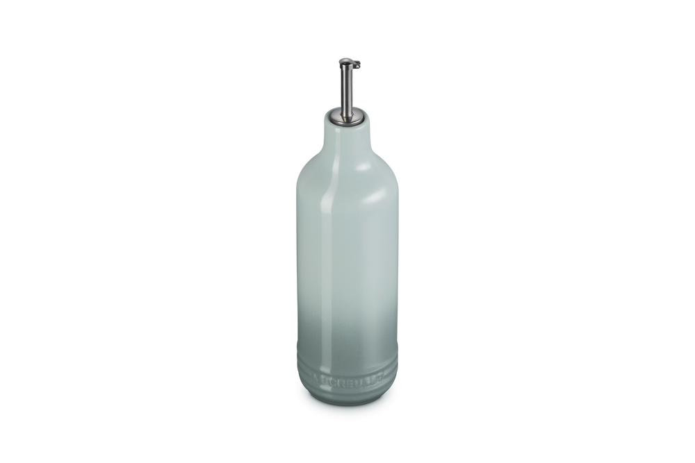 Light green ceramic oil bottle with a metallic cap on a white background