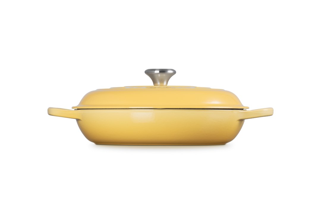 Yellow enameled cast iron casserole dish with lid on a white background