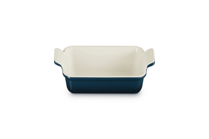 Rectangular baking dish with blue exterior and white interior on a white background