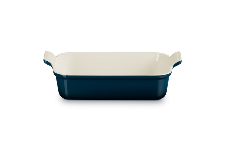 Rectangular baking dish with blue exterior and white interior on a white background