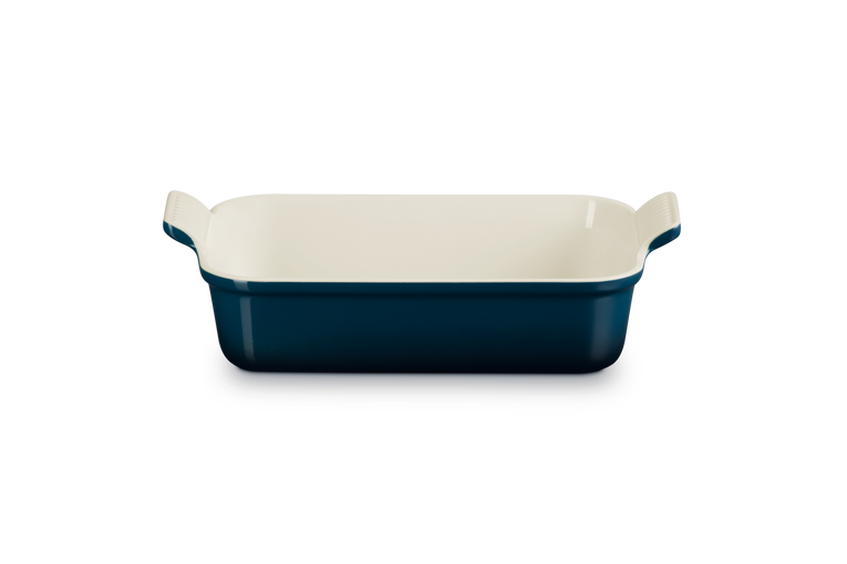 Rectangular baking dish with blue exterior and white interior on a white background