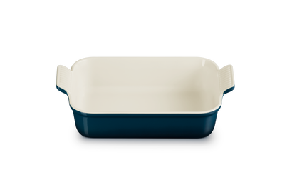 Rectangular baking dish with blue exterior and white interior on a white background