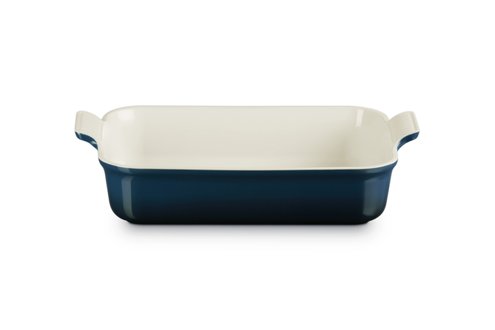 Rectangular baking dish with blue exterior and white interior on a white background