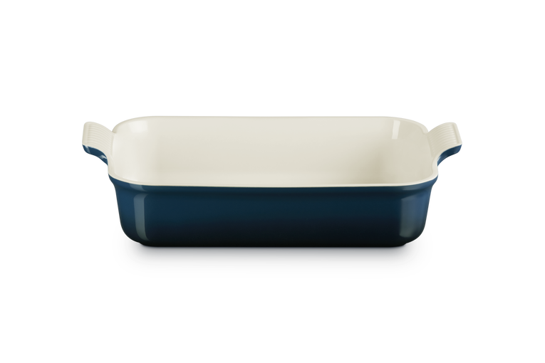 Rectangular baking dish with blue exterior and white interior on a white background