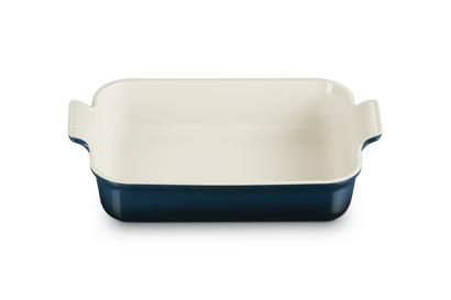 Rectangular baking dish with white interior and navy exterior on a white background