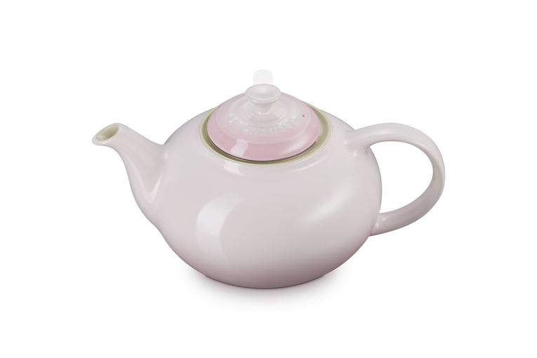 White teapot with a pink lid on a white background