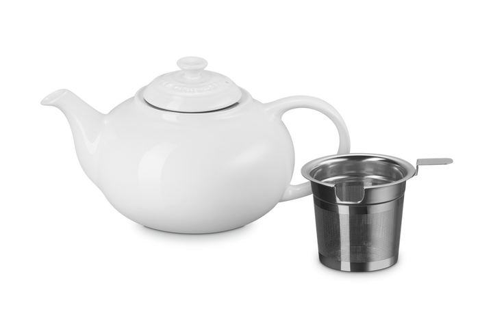 White ceramic teapot with a stainless steel infuser basket on a white background