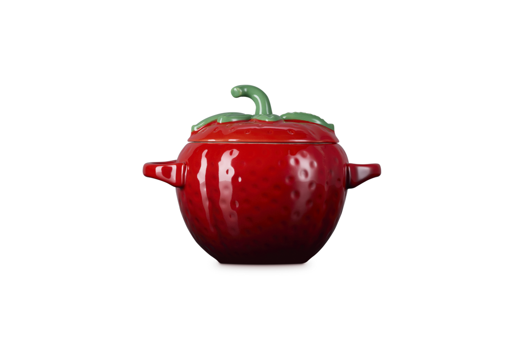 Red ceramic strawberry-shaped container on a white background