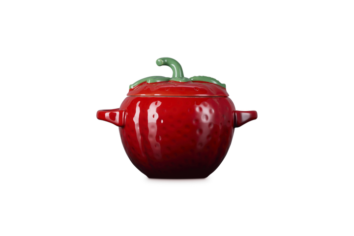 Red ceramic strawberry-shaped container on a white background