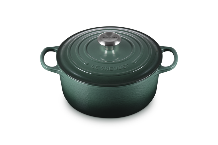 Green cast iron cookware pot with lid on a white background