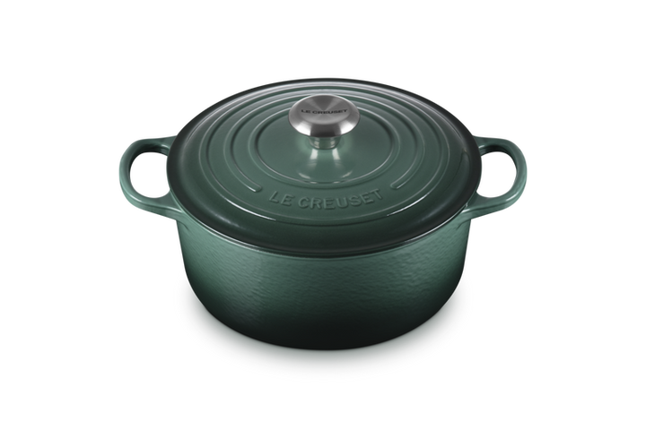 Green cast iron cookware pot with lid on a white background