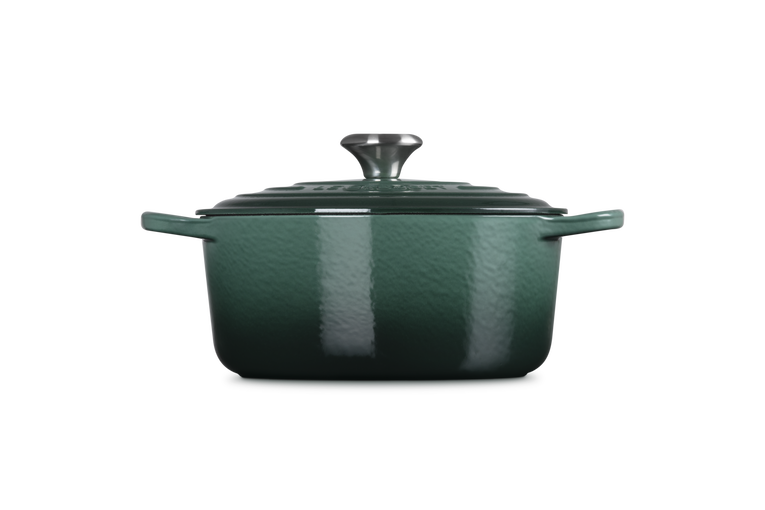 Green enameled cast iron Dutch oven on a white background