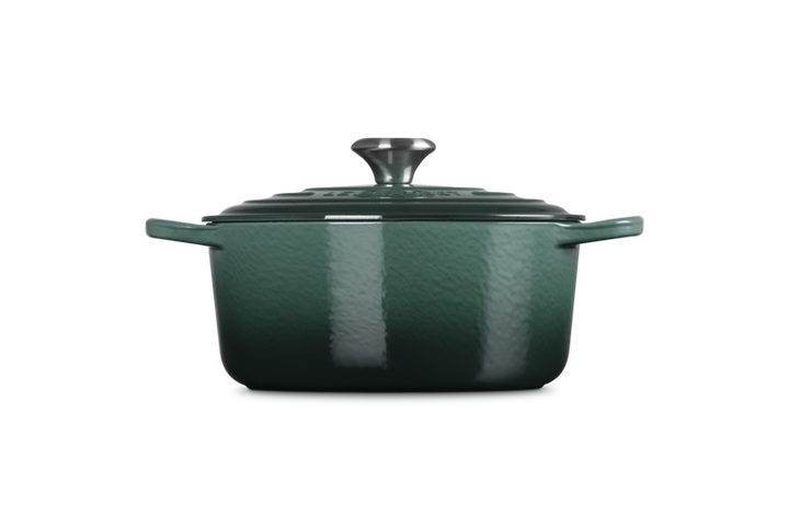 Green enameled cast iron Dutch oven on a white background