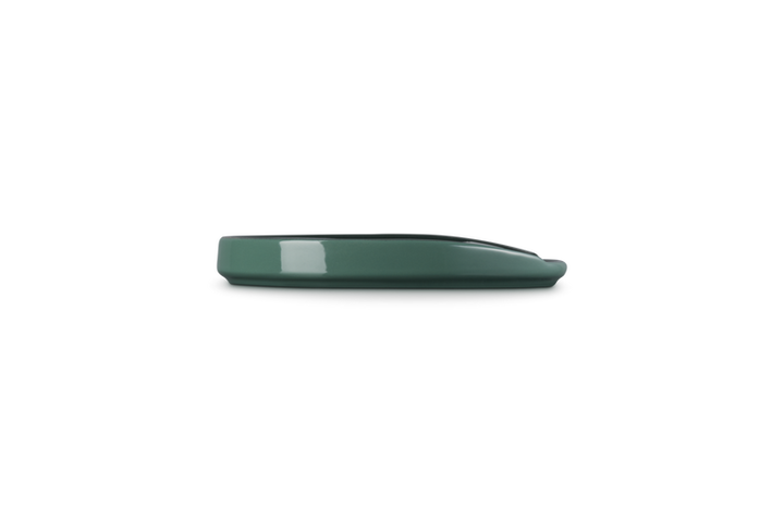 Green ceramic spoon rest on a white background