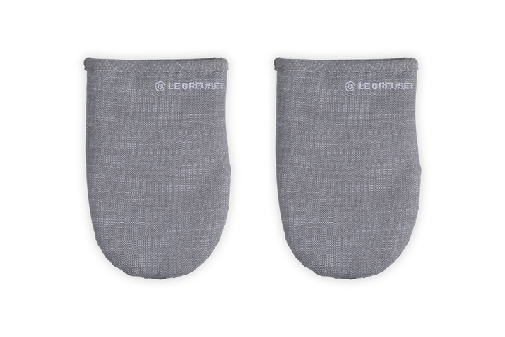 Pair of gray oven mitts with Le Creuset branding on a white background