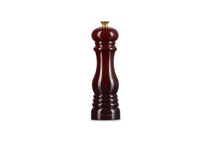 Burgundy salt grinder with a gold knob on a white background