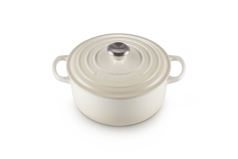 Cream enameled cast iron round Dutch oven on a white background