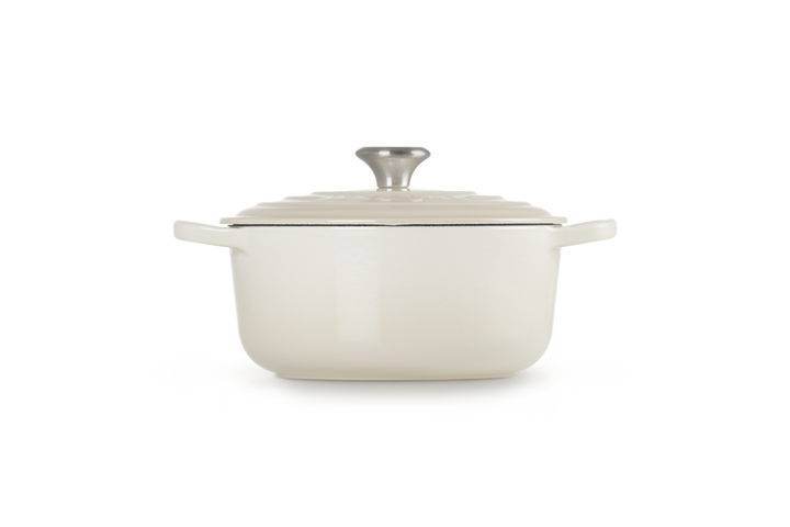 Cream enameled cast iron Dutch oven with lid on a white background