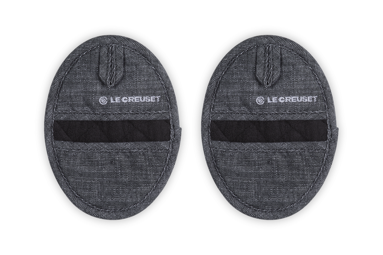 Two gray Le Creuset pot holders on a white background