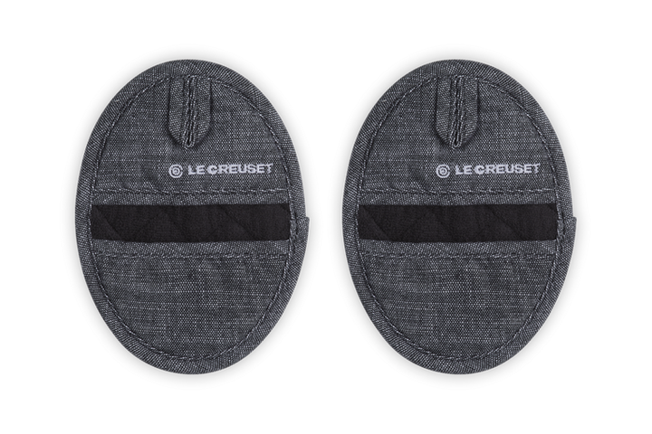 Two gray Le Creuset pot holders on a white background