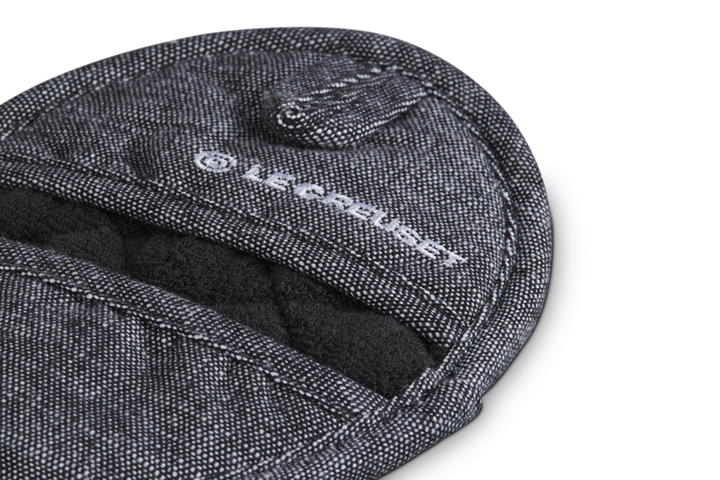 Close-up of a Le Creuset branded kitchen pot holder on a white background