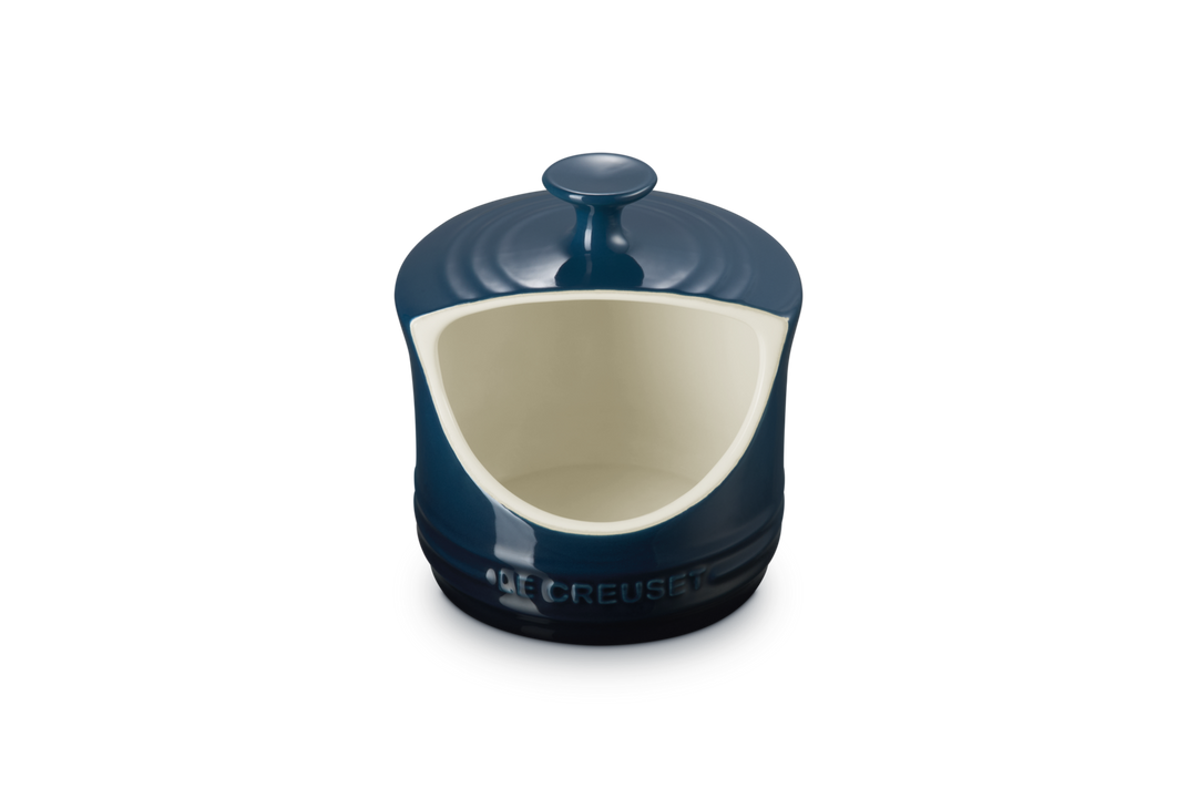 Blue ceramic salt pig with a white interior on a white background