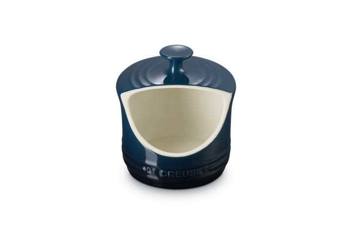 Blue ceramic salt pig with a white interior on a white background