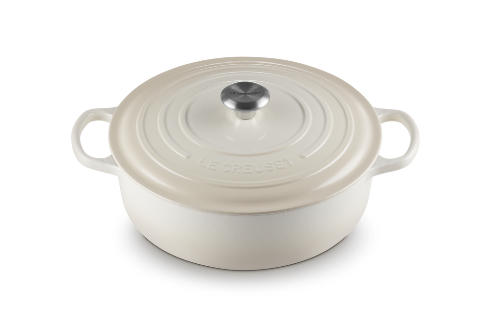 White enameled cast iron risotto pot with lid on a white background
