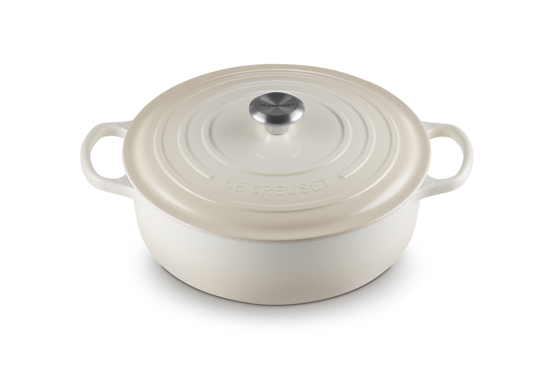 White enameled cast iron risotto pot with lid on a white background