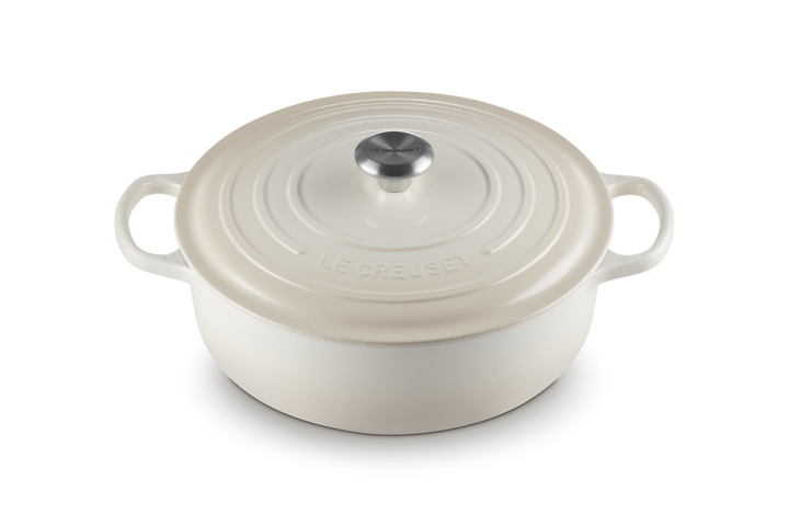 White enameled cast iron risotto pot with lid on a white background