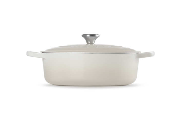 White enameled cast iron risotto pot with lid on a white background