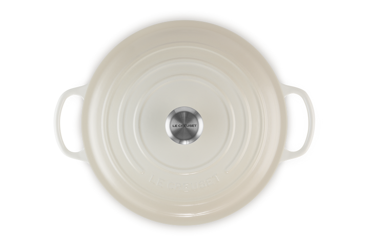 Round ceramic dish with handles on a white background