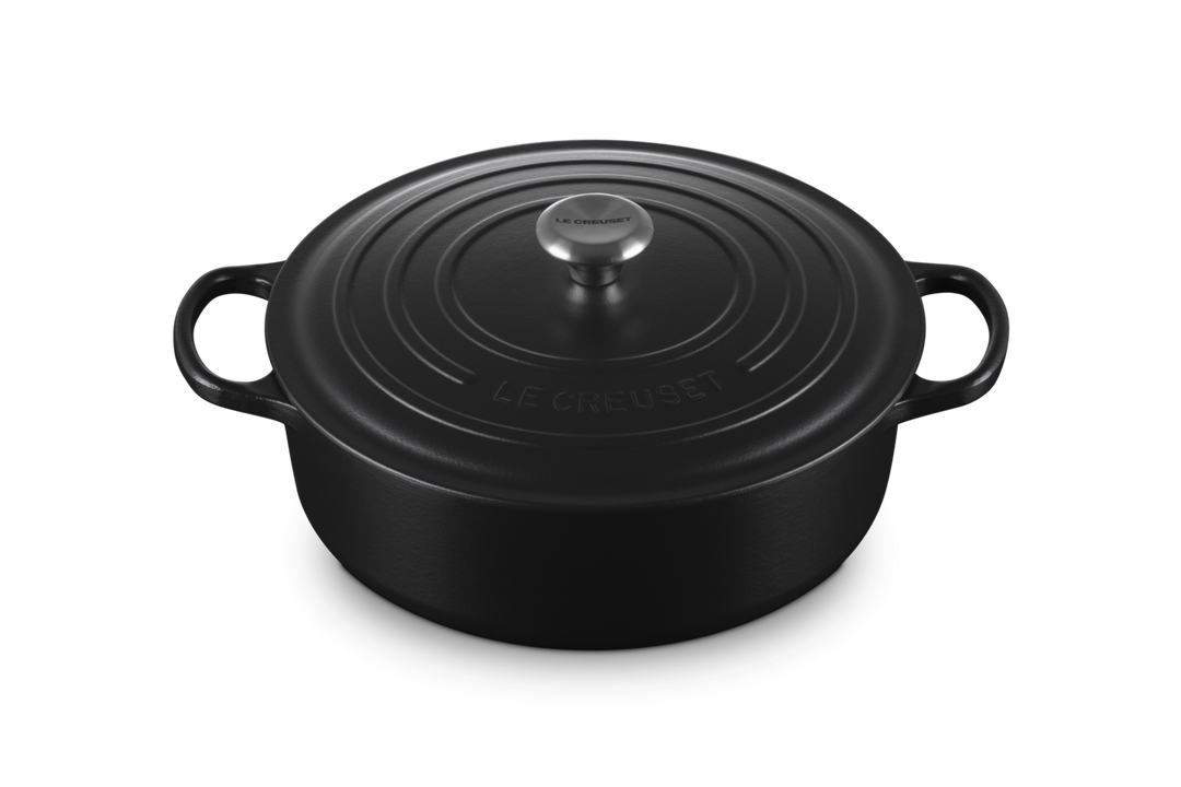 Black round Le Creuset risotto pot on a white background