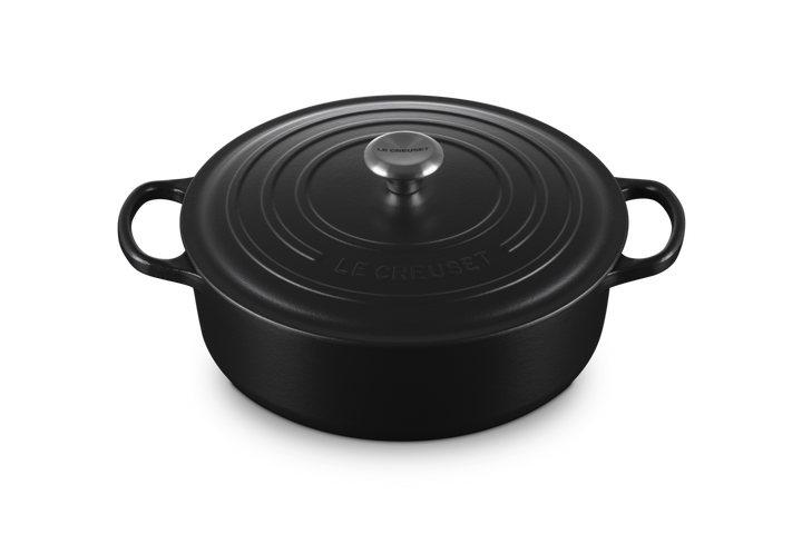 Black round Le Creuset risotto pot on a white background