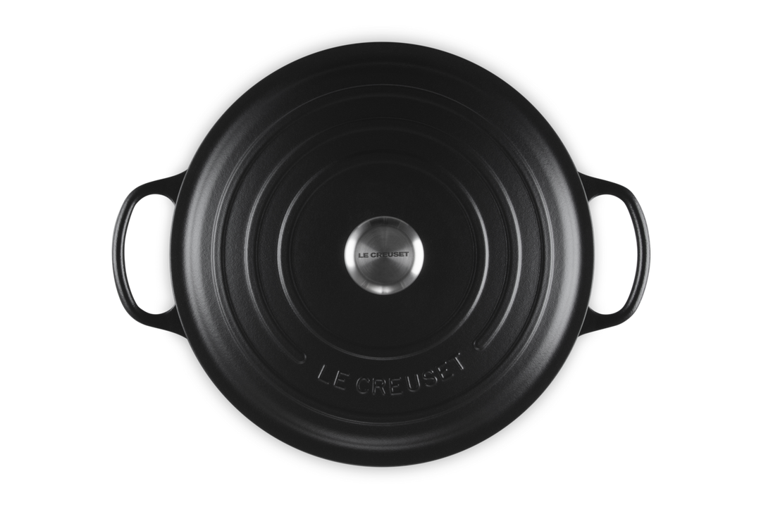 Black round Le Creuset risotto pot on a white background