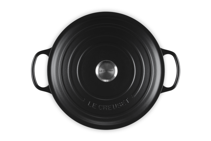 Black round Le Creuset risotto pot on a white background
