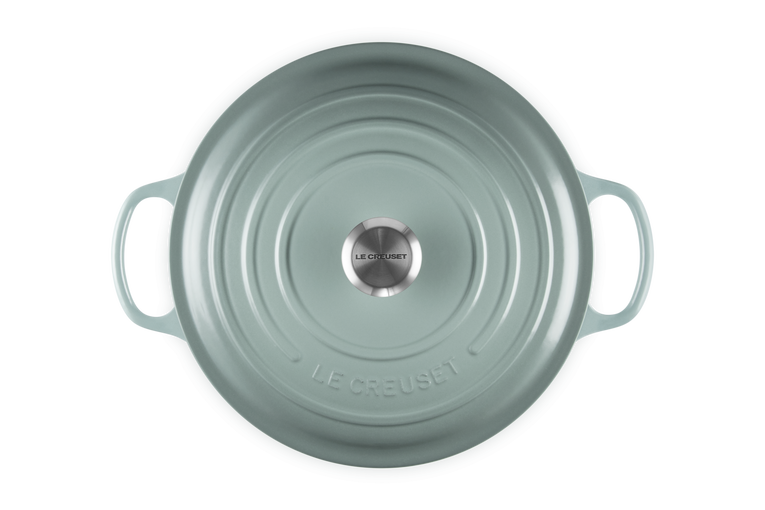 Light blue round Le Creuset risotto pot on a white background