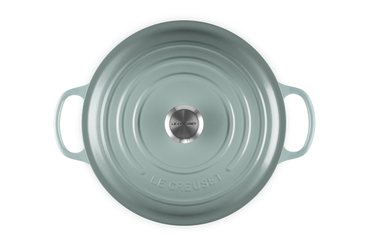 Light blue round Le Creuset risotto pot on a white background