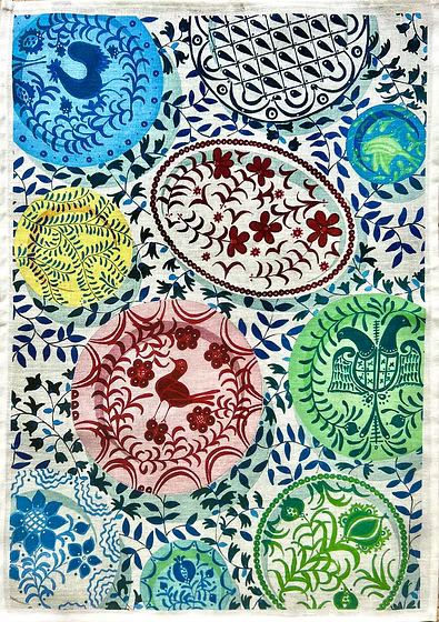 Linen tea towel with colourful painted plates on a blue and white background