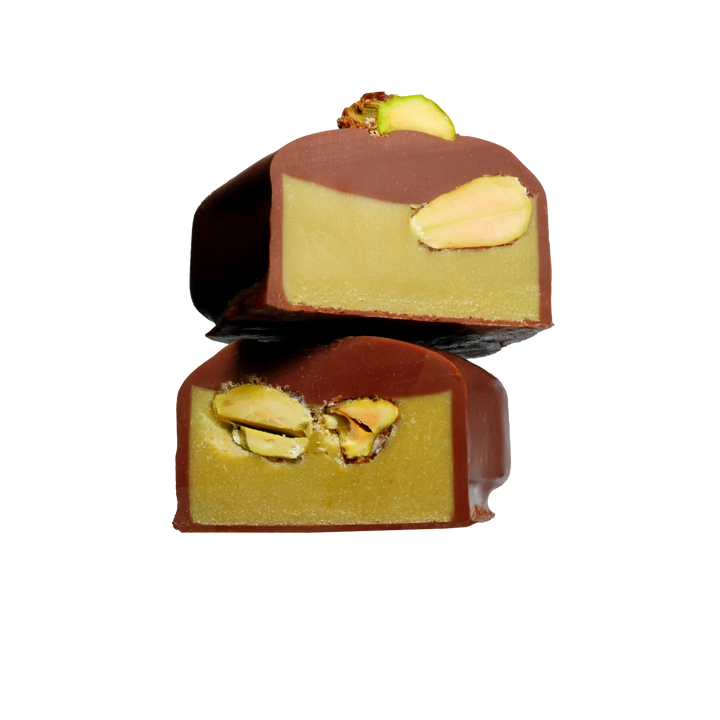 Two chocolate-covered pistachio candies on a white background