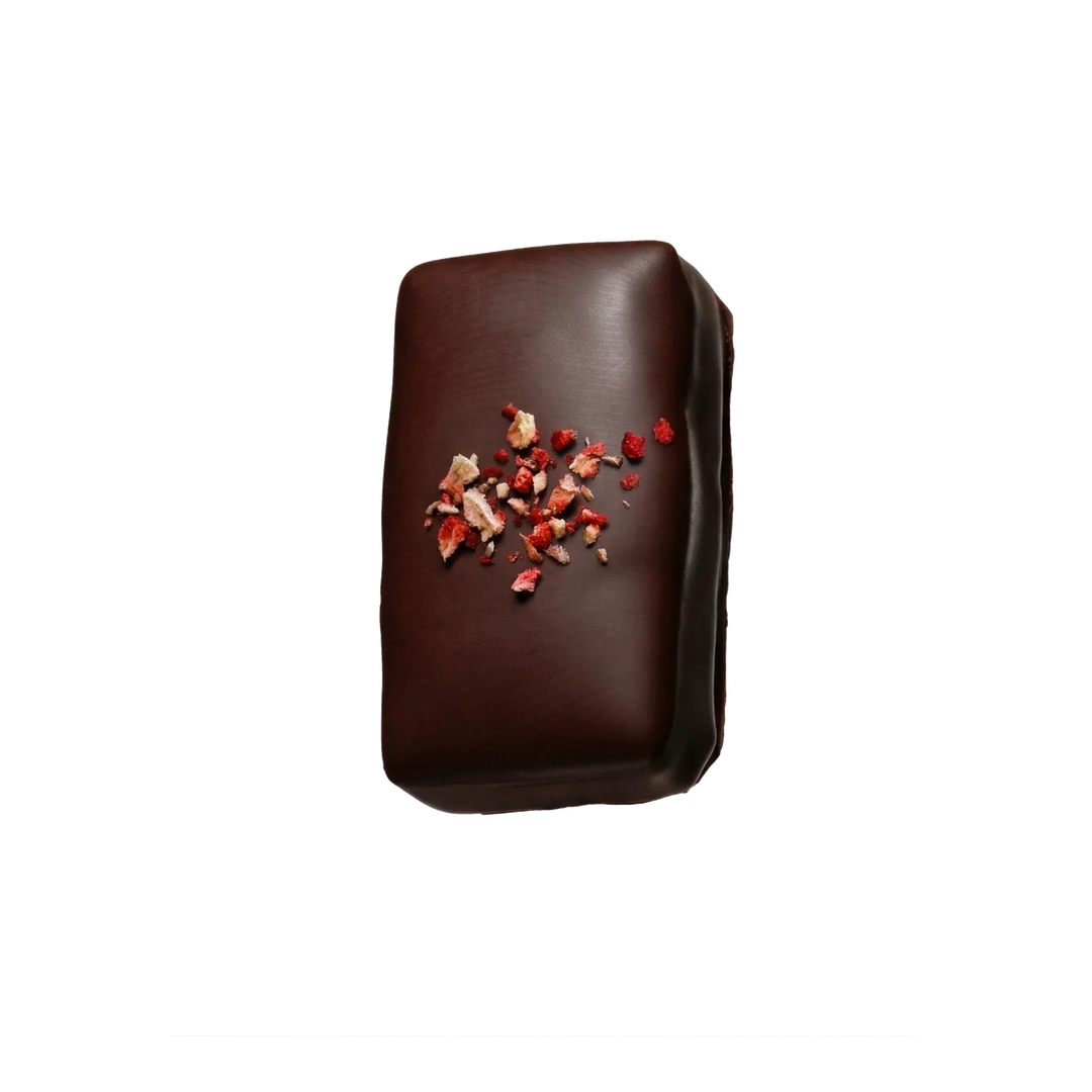 Chocolate bar with dried strawberries on top on a white background