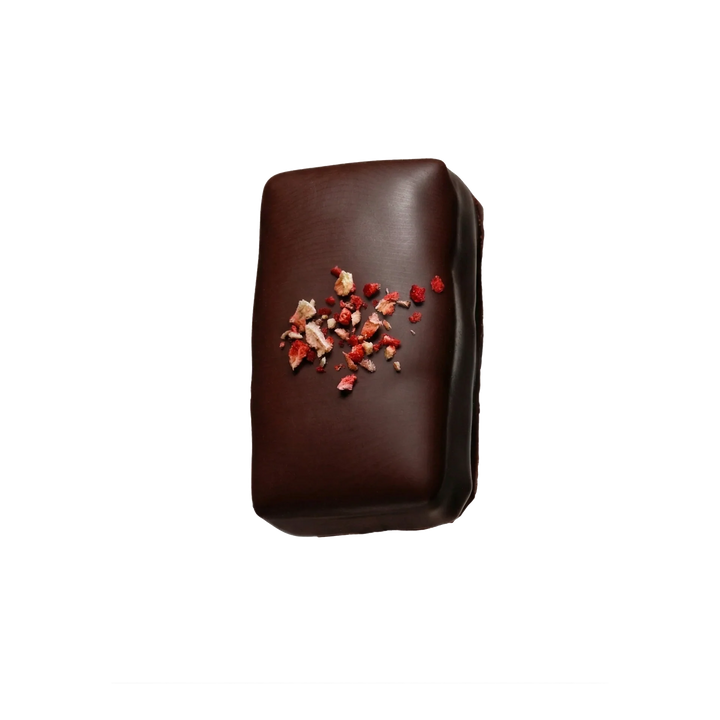 Chocolate bar with dried strawberries on top on a white background