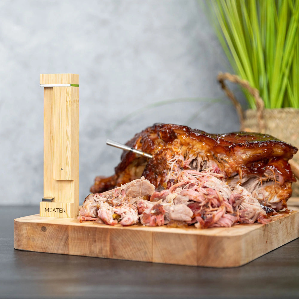 Wooden meat thermometer with pulled pork on a cutting board