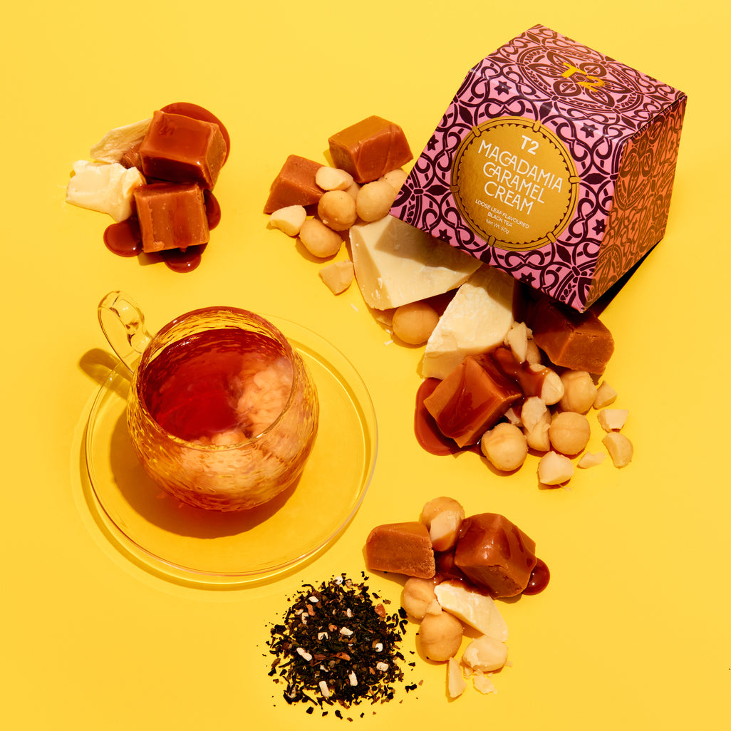 T2 Macadamia and Caramel cream tea and nuts on a yellow background