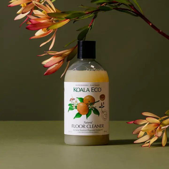 Koala Eco natural floor cleaner bottle with flowers on a green background