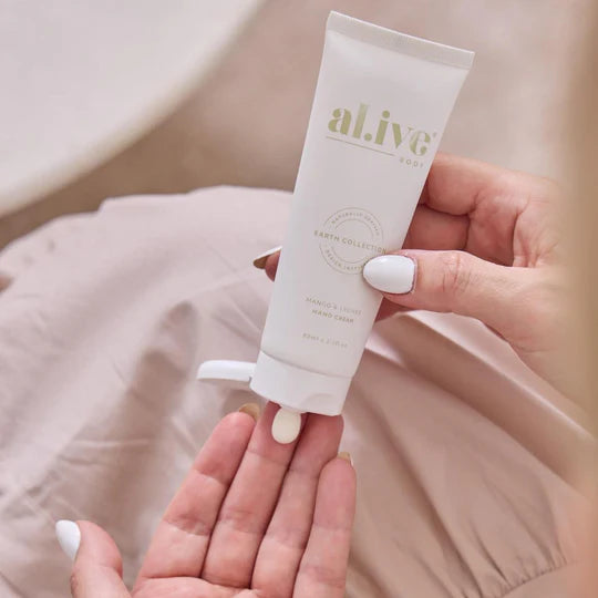 Hand holding a tube of 'alive' cream with a blurred background
