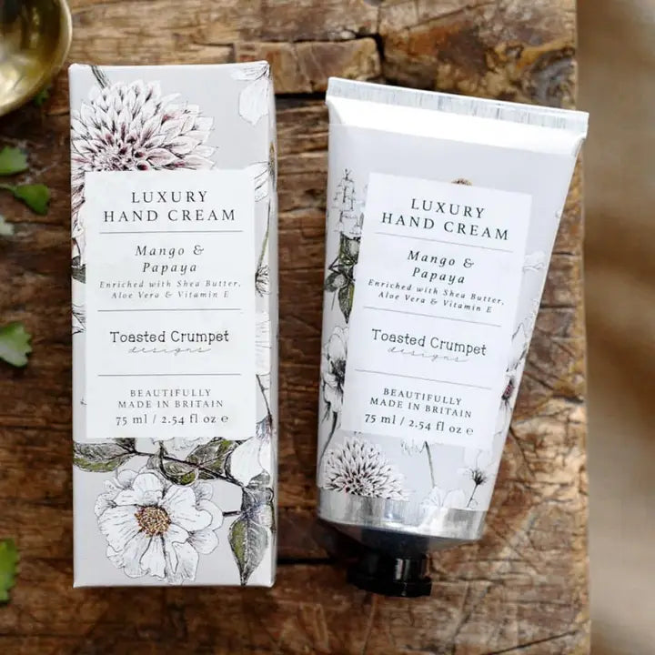 Luxury hand cream packaging with floral design on a wooden surface