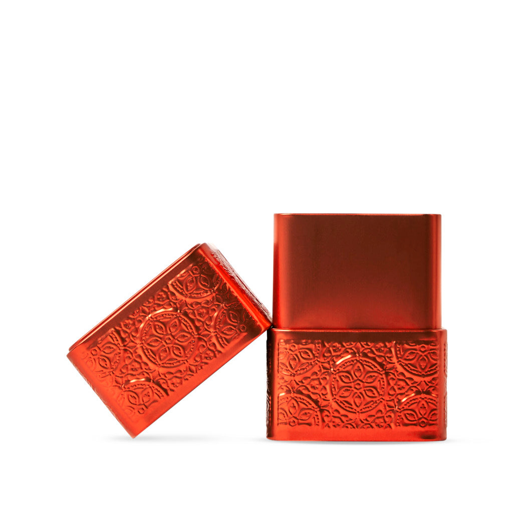 Orange metallic tin with embossed patterns on a white background
